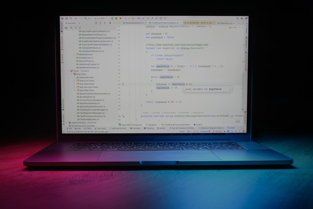 creative-02 Close-up of a laptop showing code editor under vibrant lighting, ideal for tech themes.