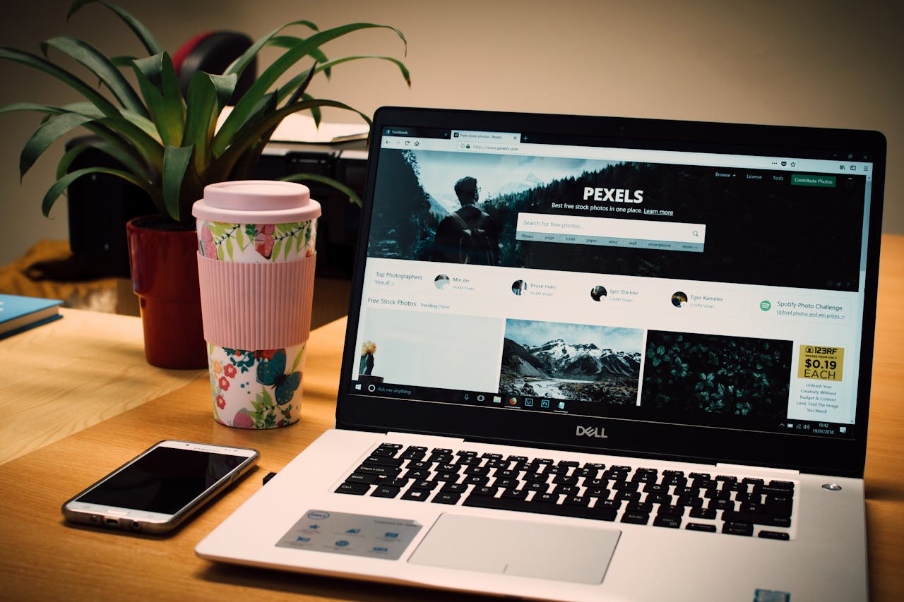 digital-01 A tidy desk setting with a laptop showing a stock photo website and a smartphone.
